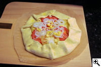 Rustic savory galette on the peel ready for the cooker.