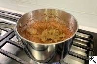 The marinade reducing in a sauce pan.