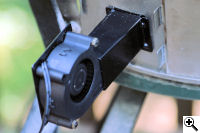 The blower attached to the adapter plate and installed on the cooker.